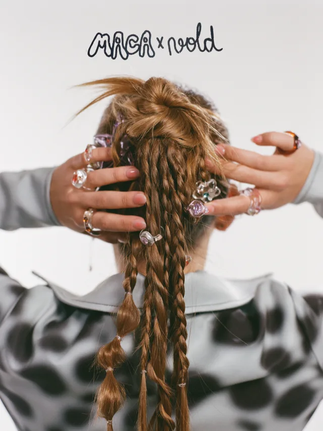 Maca de espaldas, con trenzas y anillos de Vold, y el letrero Maca x Vold